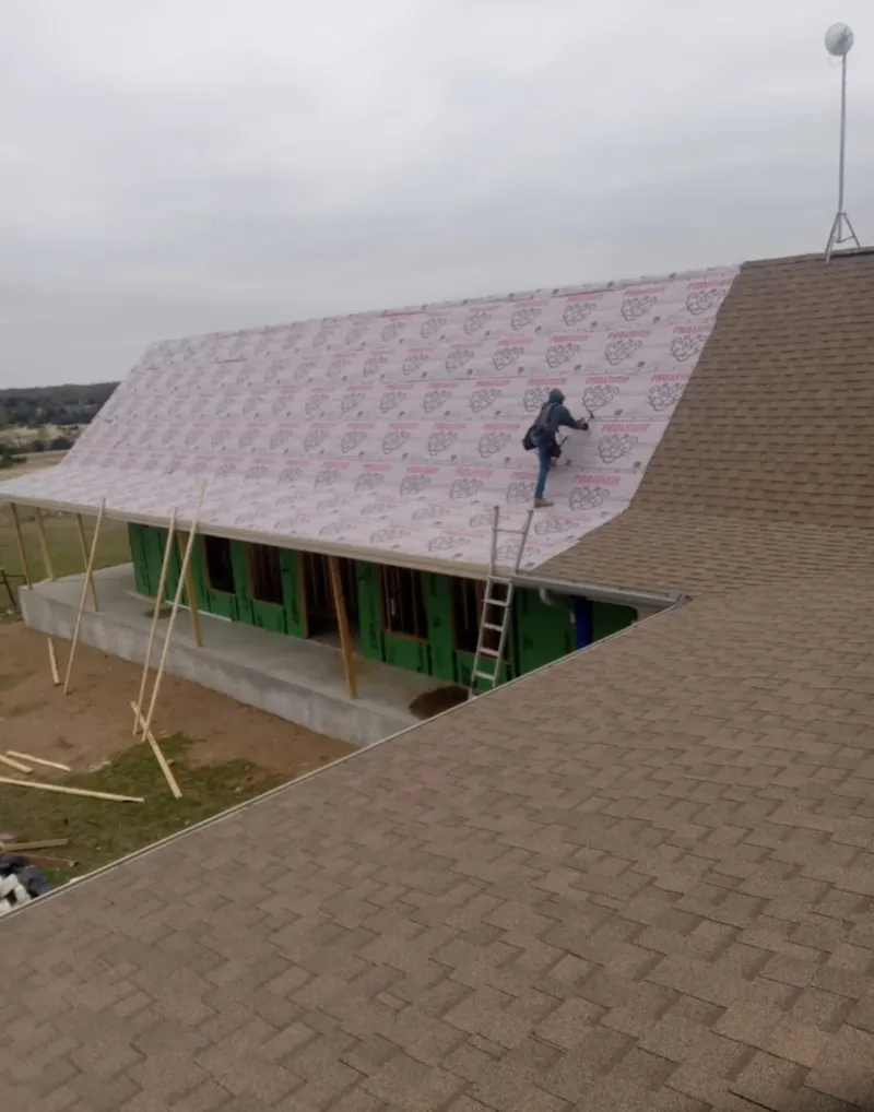 Worker preparing underlayment for a metal roof installation in Elizabethtown